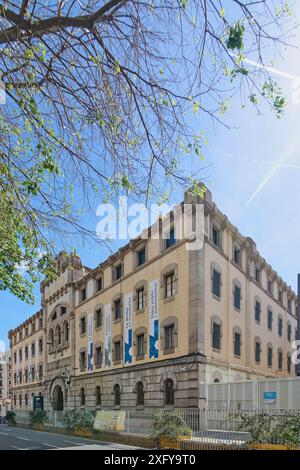 Barcelona, SPANIEN - 5. JULI 2024: Seitenansicht von Barcelonas Modellgefängnis, ein architektonisches Wahrzeichen, das an einem klaren Tag mit Schildern an der Fassade erfasst wurde. Stockfoto