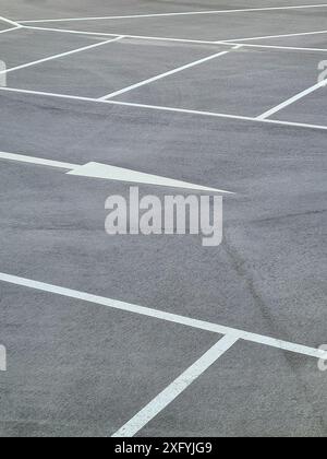 Ein Parkplatz mit weißen Markierungen für die Parkbuchten und weißen Pfeilen für die Fahrtrichtung, Parkordnung in Nordrhein-Westfalen Stockfoto