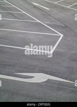 Ein Parkplatz mit weißen Markierungen für die Parkbuchten und weißen Pfeilen für die Fahrtrichtung, Parkordnung in Nordrhein-Westfalen Stockfoto