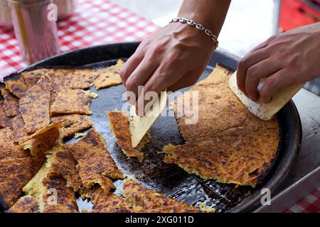 Socca, die gerade aus dem Ofen kommt, in Nizza, an der französischen Riviera. Socca ist eine Art dünner Socca, eine Spezialität der südöstlichen französischen Küche. Ein Pfannkuchen gemacht Stockfoto