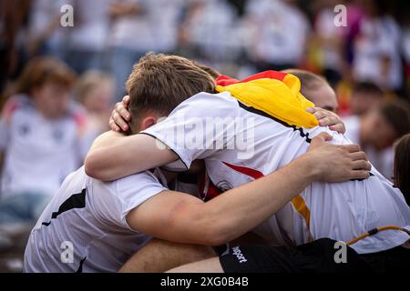 Zwei deutschland Fans sitzen niedergeschlagen am Boden und umarmen sich gegenseitig. Fans der deutschen Nationalmannschaft liegen in Traenen nach dem Spiel gegen Spanien und dem Ausscheiden aus der EURO2024 beim Fanfest mit Public Viewing auf dem Stuttgarter Schlossplatz. Foto: Eibner-Pressefoto/Dennis Duddek Stockfoto