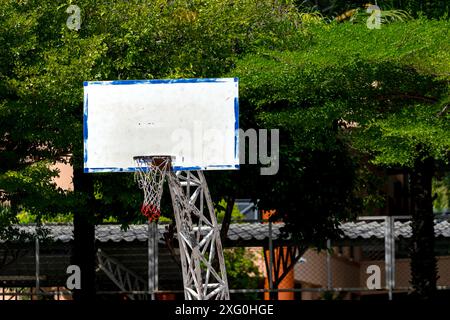 Lebendiger Basketballkorb vor klarem blauem Himmel, der die Spieler einlädt, an einem sonnigen Tag um den Basketball zu schießen, um die Essenz des Outdoor-Sports und einzufangen Stockfoto