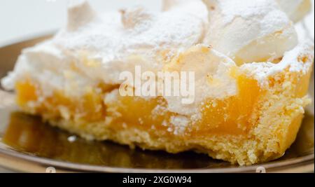 Ein Stück Kuchen mit viel Puderzucker drauf. Der Kuchen wird in zwei Hälften geschnitten und liegt auf einem Teller Stockfoto