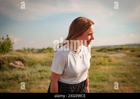 Das fröhliche Lachen einer Frau in einer sonnenverwöhnten Wiese. Stockfoto