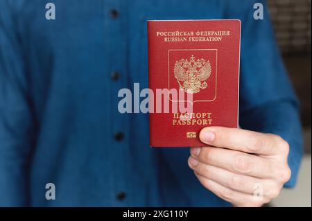Nahaufnahme der Hand eines Mannes in einem Hemd mit ausländischem Pass, das Konzept der Urlaubsvorbereitung Stockfoto