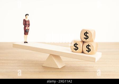 Leben und Arbeit oder Geld Balance Konzept. Geschäftsfrau Figur und Dollar-Symbol auf Holzblöcken auf hölzerner Wippe Stockfoto
