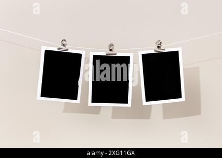 Three Blank Vintage Instant Bilderrahmen, der an einem Seil hängt. Vorlage Stockfoto