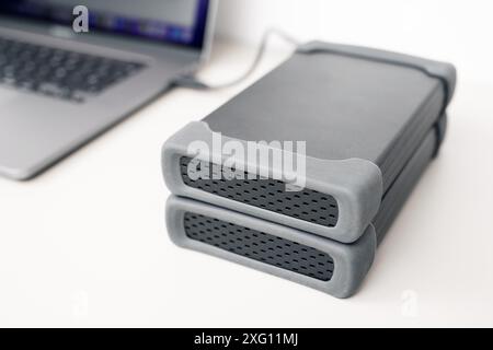 Nahaufnahme von zwei externen Festplatten Speicher mit einem modernen Laptop-Computer auf dem Schreibtisch verbunden Stockfoto