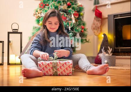 Süßes Mädchen, das weihnachten eröffnet. Hochwertige Fotografie Stockfoto