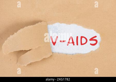 Die Worte V-aids stehen in deutscher Sprache auf zerrissenem Papier, Impfschäden, neue Autoimmunerkrankung durch Covid-19-Spritze, Immunsystem Stockfoto