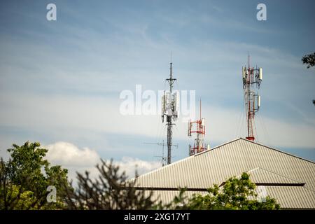 Telekommunikationsturm mit blauem Himmel und weißen Wolken, Technologiehintergrund. Stockfoto