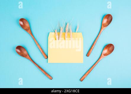 Umschlag mit Weizenohren und leeren Löffeln, Lebensmittelknappheit und steigenden Preisen, Armut durch Inflation Stockfoto