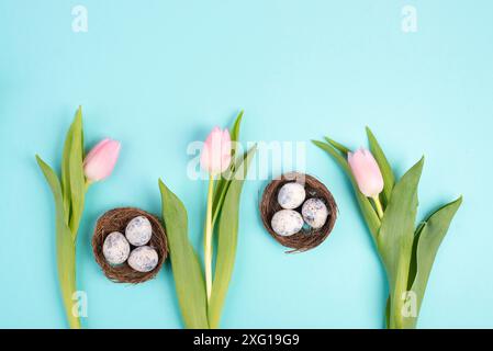 Ostereier in einem Vogelnest, rosa Tulpen, Weihnachtsgrußkarte, Hintergrund der Frühlingssaison Stockfoto