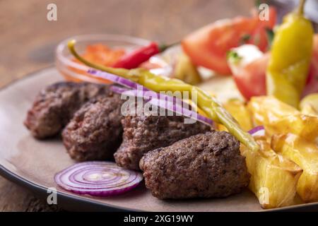 Cevapcici auf einer Platte mit Spänen Stockfoto