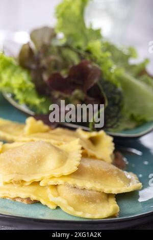 Ravioli mit Sahnesauce und Salat Stockfoto