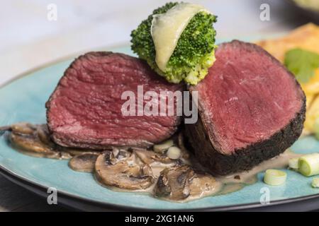 Geschnittenes Steak und Kartoffelgratin auf einem Teller Stockfoto