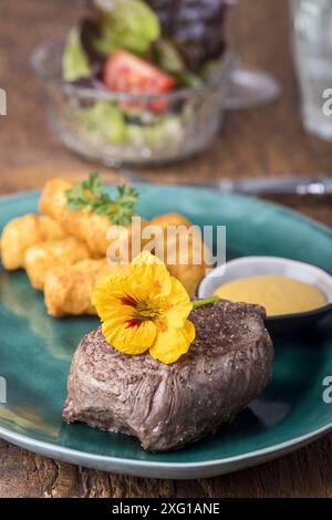 Steak mit Kroketten auf Holz Stockfoto