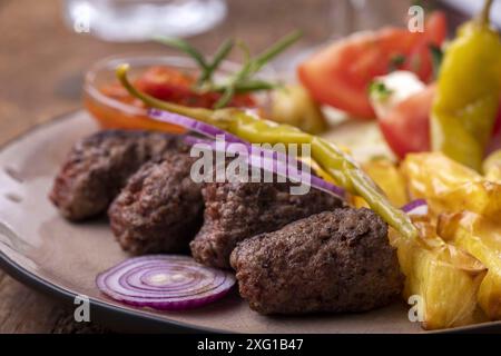 Cevapcici auf einer Platte mit Spänen Stockfoto