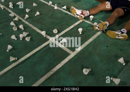 Shuttlecocks auf dem Badmintonfeld vor jungen Badmintonsportlern, die sich nach einem Training in Jakarta, Indonesien, ausruhen. Stockfoto