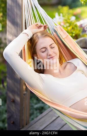Entspannen in der Hängematte, Frau genießt friedliche Momente im Freien im Garten Stockfoto