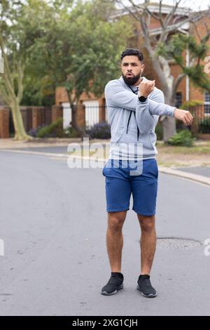 Sich draußen ausdehnen, Mann in Sportkleidung, der sich auf den Lauf in der Nachbarschaft vorbereitet, Kopierraum Stockfoto