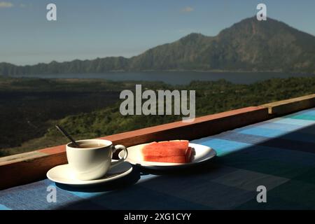 Wassermelone und Tee auf einem Restauranttisch im Hintergrund des Mount Batur in Kintamani, Bangli, Bali, Indonesien. Stockfoto