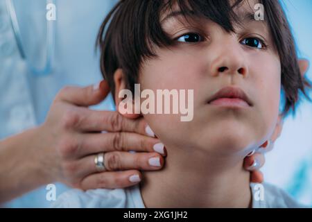 Pädiatrischer Endokrinologe , Untersuchung geschwollener Lymphknoten eines Jungen. Stockfoto