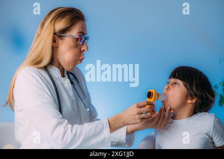 Pädiatrischer Pulmonologe zur Messung der Lungenkapazität und des exspiratorischen Volumens eines Jungen. Stockfoto