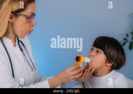 Pädiatrischer Pulmonologe zur Messung der Lungenkapazität und des exspiratorischen Volumens eines Jungen. Stockfoto