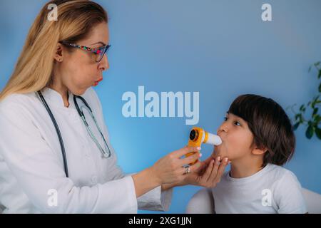 Pädiatrischer Pulmonologe zur Messung der Lungenkapazität und des exspiratorischen Volumens eines Jungen. Stockfoto