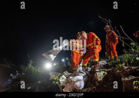 (240706) -- YUEYANG, 6. Juli 2024 (Xinhua) -- Retter verstärken einen Deich in der Gemeinde Tuanzhou, County Huarong unter der Stadt Yueyang, zentralchinesische Provinz Hunan, 6. Juli 2024. Rettungskräfte, darunter Feuerwehrleute und bewaffnete Polizisten, überwachen genau die Situation eines Deichbruchs im Dongting Lake in der zentralchinesischen Provinz Hunan, der am Freitagnachmittag stattfand, sagten die lokalen Behörden. Die Bresche war ursprünglich etwa 10 Meter breit, hat sich seitdem jedoch weiter ausgebreitet. Die Verlegung von ca. 5.000 Bewohnern des betroffenen Bereichs wurde nach Auskunft des örtlichen Hochwasserschutzes abgeschlossen Stockfoto