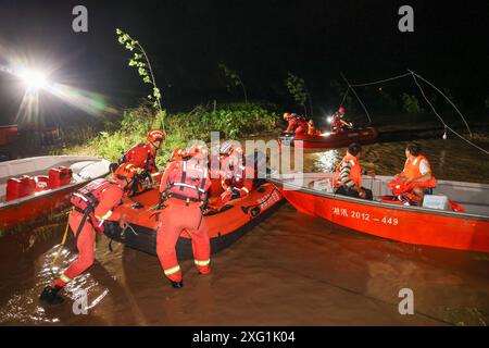 (240706) -- YUEYANG, 6. Juli 2024 (Xinhua) -- Retter verlegen gestrandete Bewohner in der Gemeinde Tuanzhou, County Huarong unter der Stadt Yueyang, zentralchinesische Provinz Hunan, 6. Juli 2024. Rettungskräfte, darunter Feuerwehrleute und bewaffnete Polizisten, überwachen genau die Situation eines Deichbruchs im Dongting Lake in der zentralchinesischen Provinz Hunan, der am Freitagnachmittag stattfand, sagten die lokalen Behörden. Die Bresche war ursprünglich etwa 10 Meter breit, hat sich seitdem jedoch weiter ausgebreitet. Nach Angaben des örtlichen flo wurde die Verlegung von ca. 5.000 Bewohnern des betroffenen Bereichs abgeschlossen Stockfoto