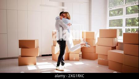Begeisterte junge Familie, die ihr Traumhaus kauft, feiert mit einem freudigen Einzugstag in weißen Hauskisten Stockfoto