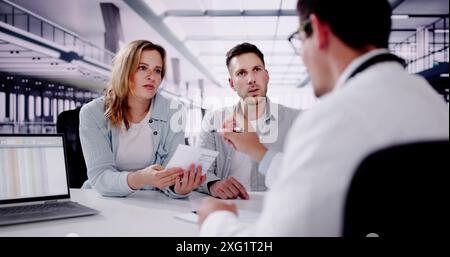 Lächelnder hispanischer Arzt gibt Versicherung Rezept an junge schwangere Paare im medizinischen Büro für Gesundheitsberatung. Stockfoto