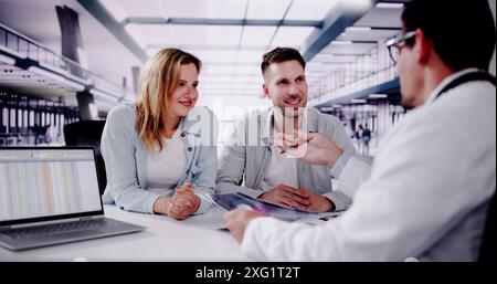 Lächelnder Arzt erklärt Schwangerschaftstestergebnisse dem werdenden Paar in der Klinik - Arzt in Beratung mit Patienten. Stockfoto