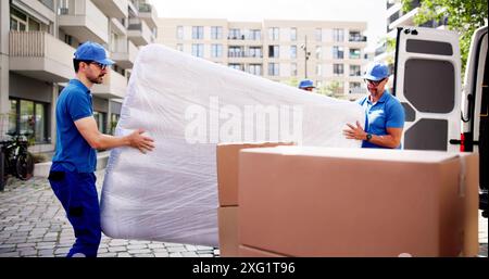 Professional Movers liefern Wickelmatratzen in urbaner Umgebung: Ein zuverlässiger, effizienter Service für stressfreie Umsiedlung. Stockfoto