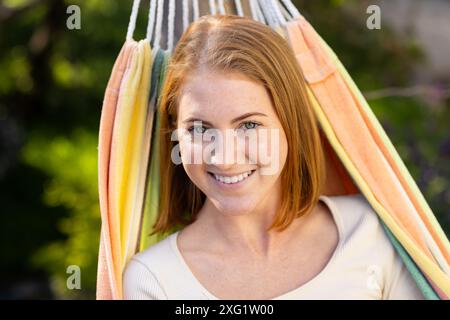 Entspannen Sie sich in der Hängematte, lächelnde Frau und genießen Sie Freizeit im Freien Stockfoto