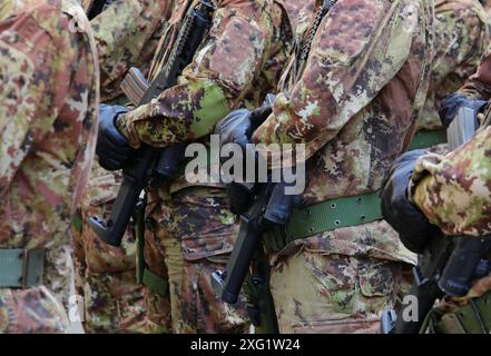 Truppe von Soldaten in grünen und braunen Tarnuniformen, schwarzen Handschuhen und Sturmgewehren in den Händen. Stockfoto
