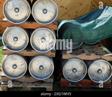 Bierfässer aus Aluminium, die vor einer Brauerei auf Paletten gestapelt werden Stockfoto