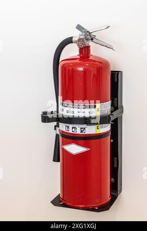 Roter Feuerlöscher aus der Nähe des Feuerlöschers hängt an der Wand im Hotel. Stockfoto