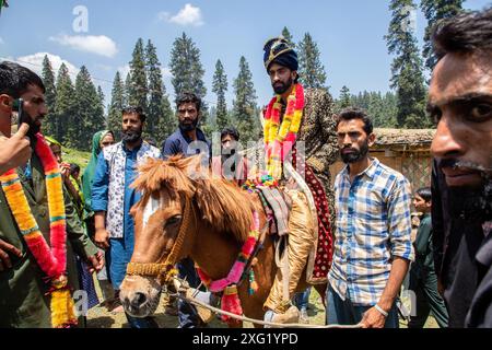 Freunde und Verwandte machen Fotos von einem Gujjar (Nomaden) Bräutigam, bevor sie während der Hochzeitszeremonie im Dorf Sangerwani im Bezirk Pulwama, 75 km südlich von Srinagar, der Sommerhauptstadt der Himalaya-Region in Kaschmir, zum Haus der Braut aufbrechen. Trotz der exponentiellen Entwicklung von Autos verwenden einige nomadische Stämme noch Pferde und Palanquins für Hochzeiten. Eine neue Studie der Tribal Research and Cultural Foundation, einer Frontalorganisation der Gujjar-Gemeinschaft, zeigt, dass 88 Prozent der Gujjars (Nomaden) in Jammu und Kaschmir bis zu 600 US-Dollar für eine Ehe ausgeben Stockfoto