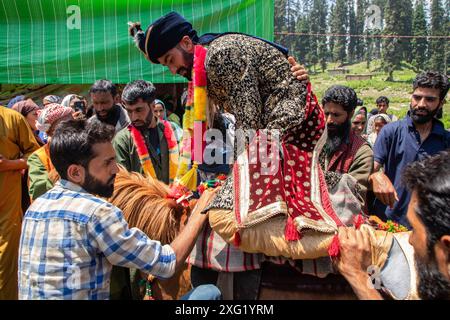 Ein Bräutigam aus Gujjar (Nomade) verlässt sich während der Hochzeitszeremonie im Dorf Sangerwani im Bezirk Pulwama, 75 km südlich von Srinagar, der Sommerhauptstadt der Himalaya-Region in Kaschmir. Trotz der exponentiellen Entwicklung von Autos verwenden einige nomadische Stämme noch Pferde und Palanquins für Hochzeiten. Eine neue Studie der Tribal Research and Cultural Foundation, einer Frontalorganisation der Gujjar-Gemeinschaft, zeigt, dass 88 Prozent der Gujjars (Nomaden) in Jammu und Kaschmir bis zu 600 US-Dollar für eine Hochzeitszeremonie ausgeben und 89 Prozent der Gujjars (Nomen) Stockfoto