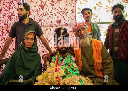 Eltern und Verwandte machen Fotos mit einem Gujjar (Nomaden) Bräutigam, bevor sie während der Hochzeitszeremonie im Dorf Sangerwani im Bezirk Pulwama, 75 km südlich von Srinagar, der Sommerhauptstadt der Himalaya-Region in Kaschmir, zum Heim der Braut aufbrechen. Trotz der exponentiellen Entwicklung von Autos verwenden einige nomadische Stämme noch Pferde und Palanquins für Hochzeiten. Eine neue Studie der Tribal Research and Cultural Foundation, einer Frontalorganisation der Gujjar-Gemeinschaft, zeigt, dass 88 Prozent der Gujjars (Nomaden) in Jammu und Kaschmir bis zu 600 US-Dollar für eine Ehe ausgeben Stockfoto