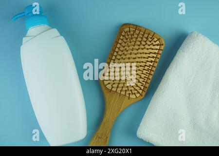 Shampooflaschen, Kämme und Handtücher Körperreinigungsausrüstung auf blauem Hintergrund Stockfoto
