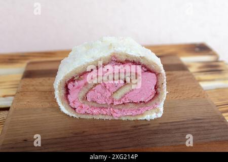 Schweizer Brötchen gefüllt mit rosafarbener Creme und garniert getrockneter Kokosnuss Stockfoto