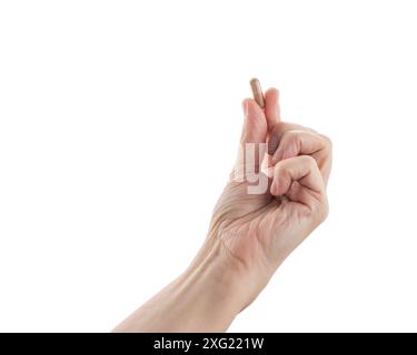 Frauen mittleren Alters halten beige Tabletten isoliert auf weiß Stockfoto