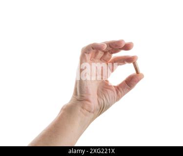 Frauen mittleren Alters halten beige Tabletten isoliert auf weiß Stockfoto