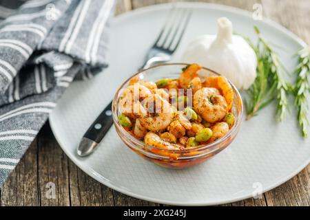 Frischer Salat mit Garnelen und Edamame Sojabohnen in einer Schüssel auf einem Holztisch. Stockfoto