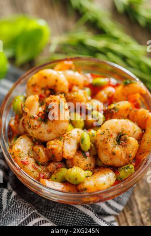 Frischer Salat mit Garnelen und Edamame Sojabohnen in einer Schüssel auf einem Holztisch. Stockfoto