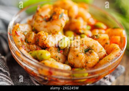 Frischer Salat mit Garnelen und Edamame Sojabohnen in einer Schüssel auf einem Holztisch. Stockfoto